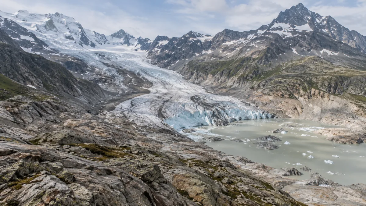 Ghiacciaio alpino, rocce esposte e acqua di fusione · illustrazione AI